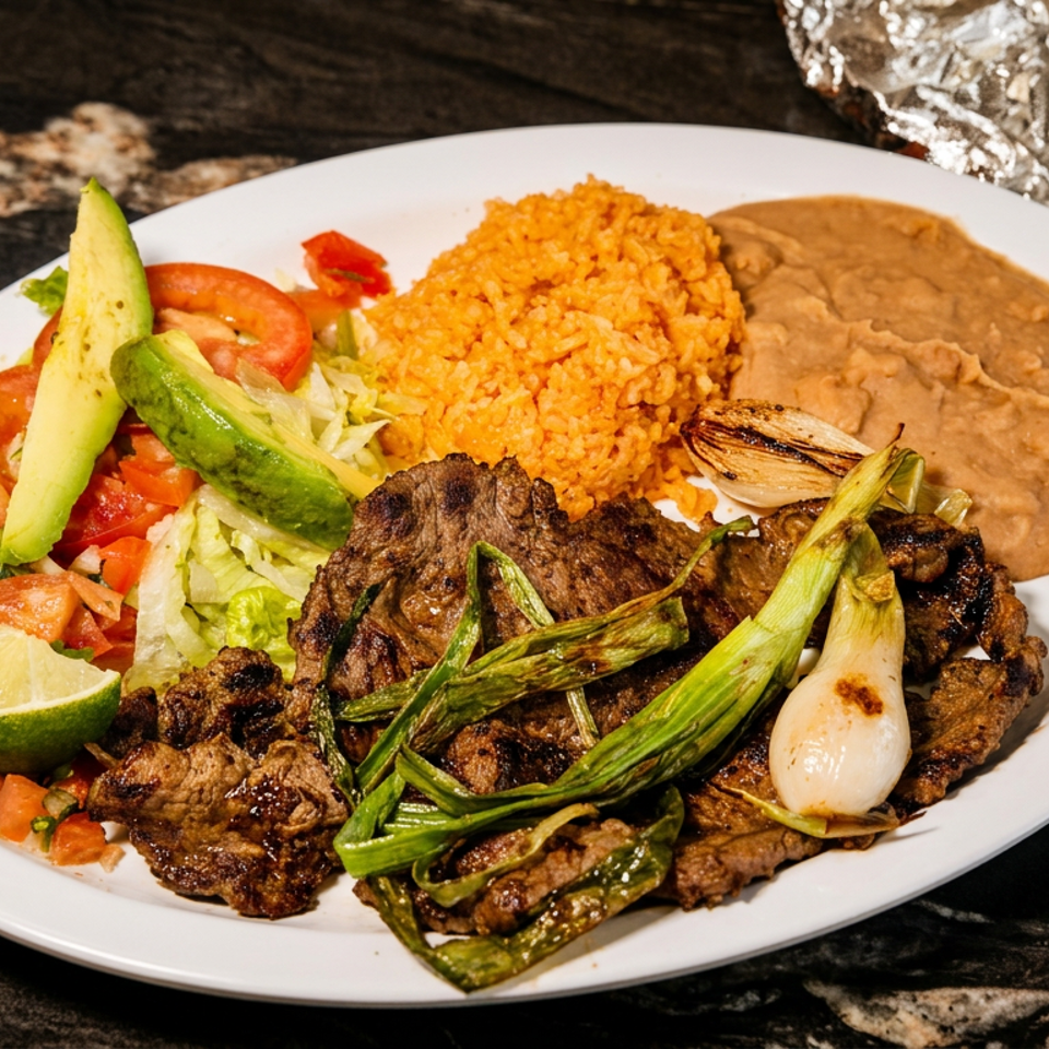 Grilled steak with onions, rice, refried beans, salad, avocado, and lime on a white plate.